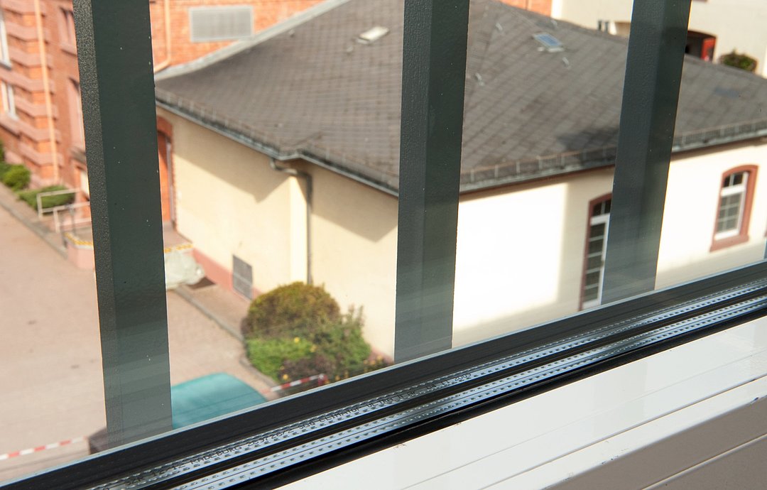 Blick in den Innenhof der Klinik für forensische Psychiatrie Eltville durch ein vergittertes Fenster