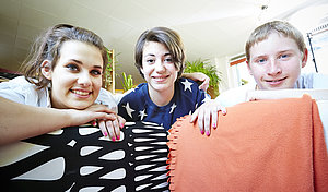 Drei Jugendliche hängen auf der Couch